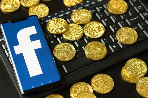 imagem de moedas em cima do teclado com a logo do facebook sobre ganhar dinheiro